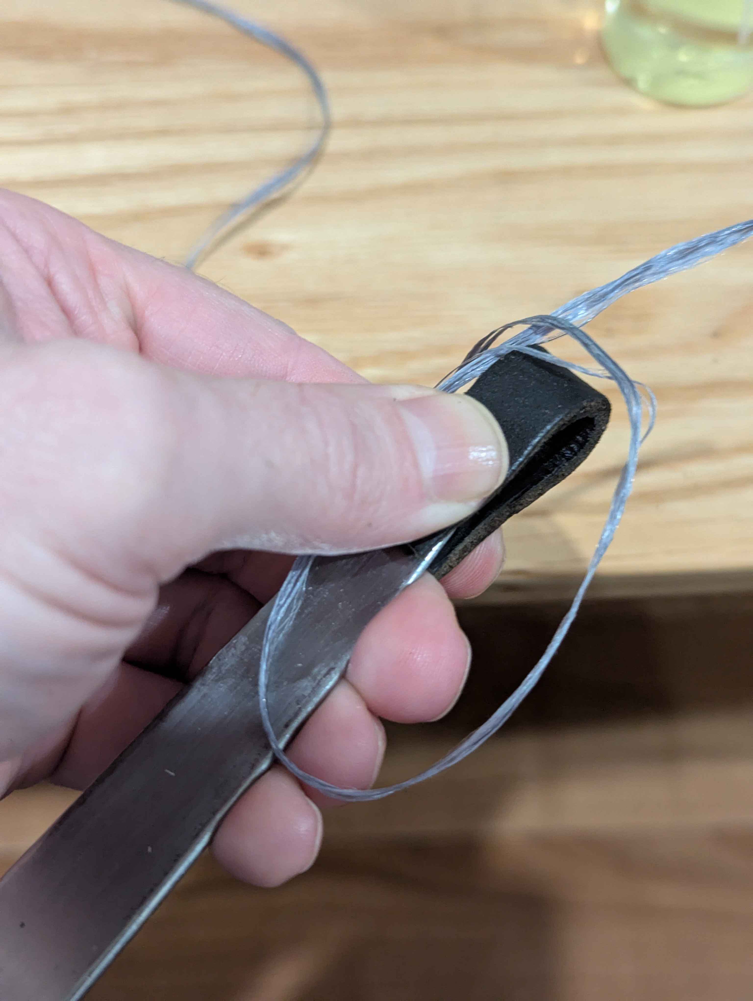 Initial loop of the string on the leather